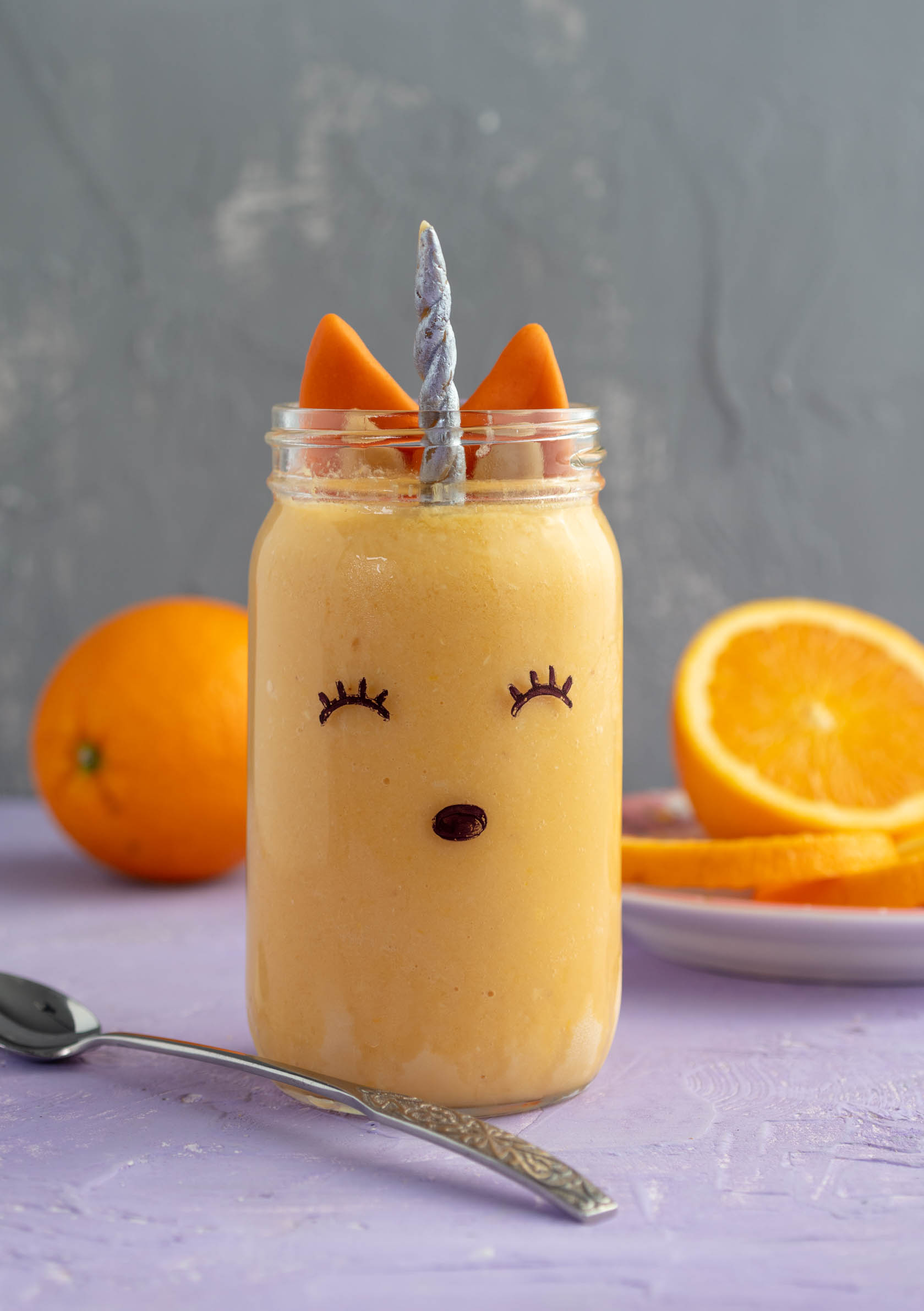 vegan orange julius in a glass decorated to look like a fox unicorn