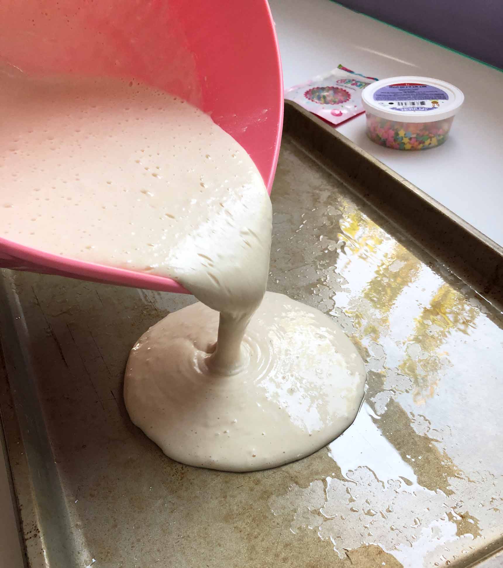 pouring the vegan pancake batter into the sheet pan