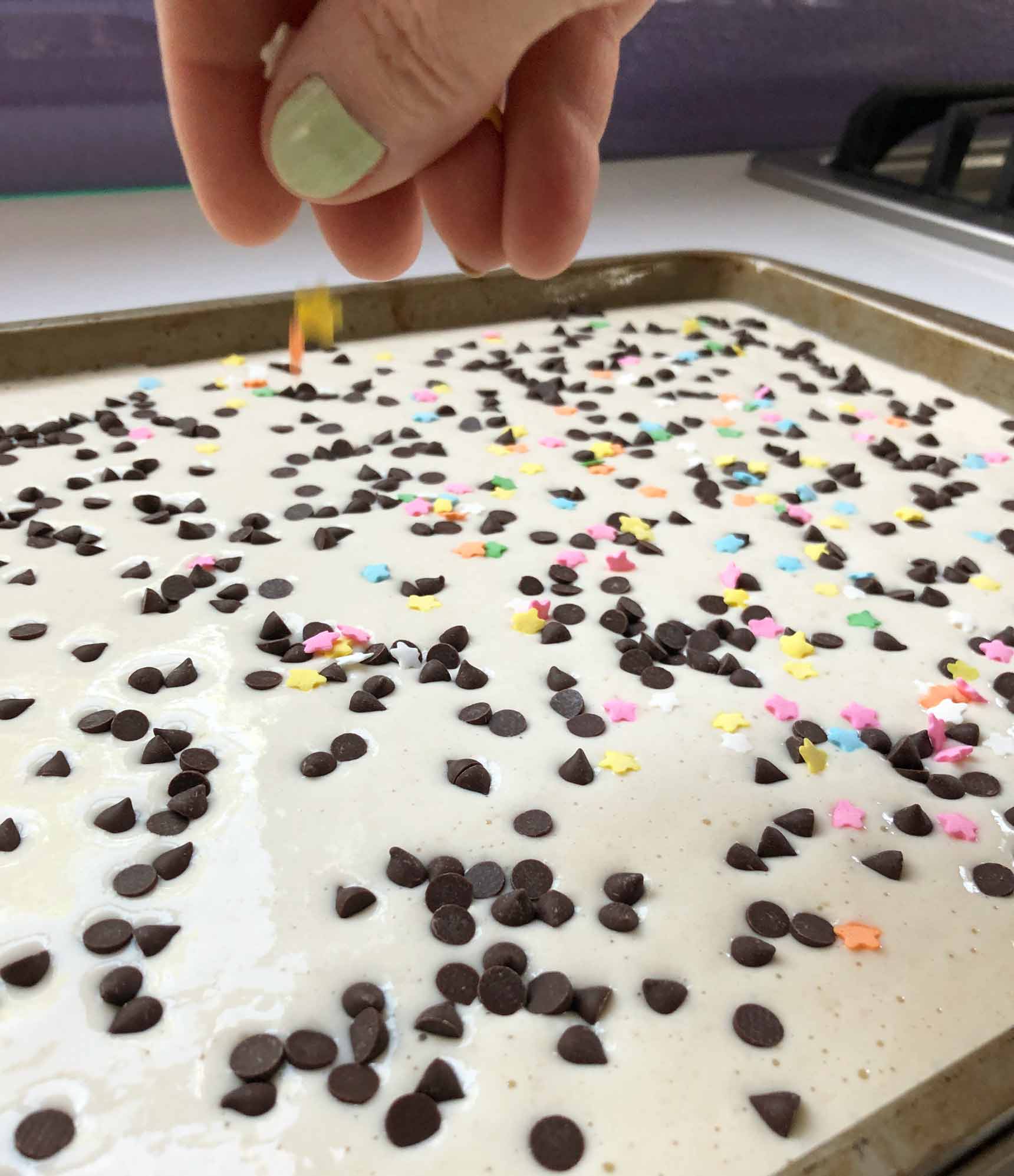 adding sprinkles to the vegan sheet pan pancake batter