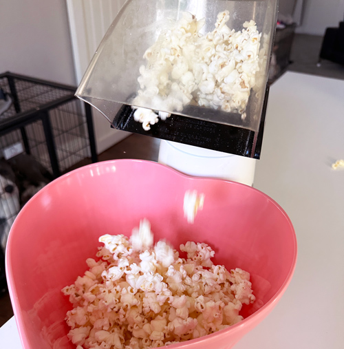 popping corn with an air popper into a pink heart shaped bowl