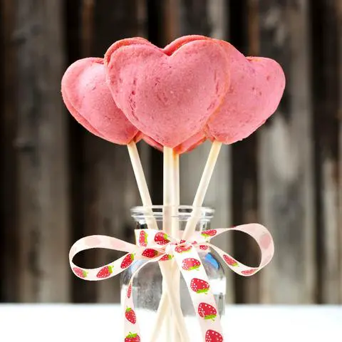 pink heart-shaped pie pops in a mini vase wrapped with a ribbon