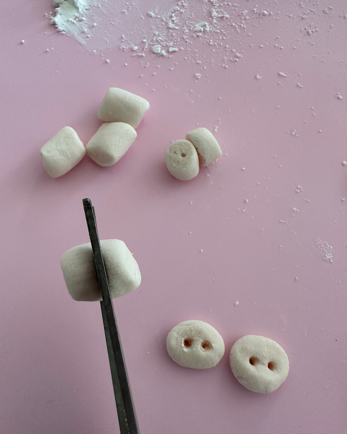 cutting a mini vegan marshmallow with scissors.