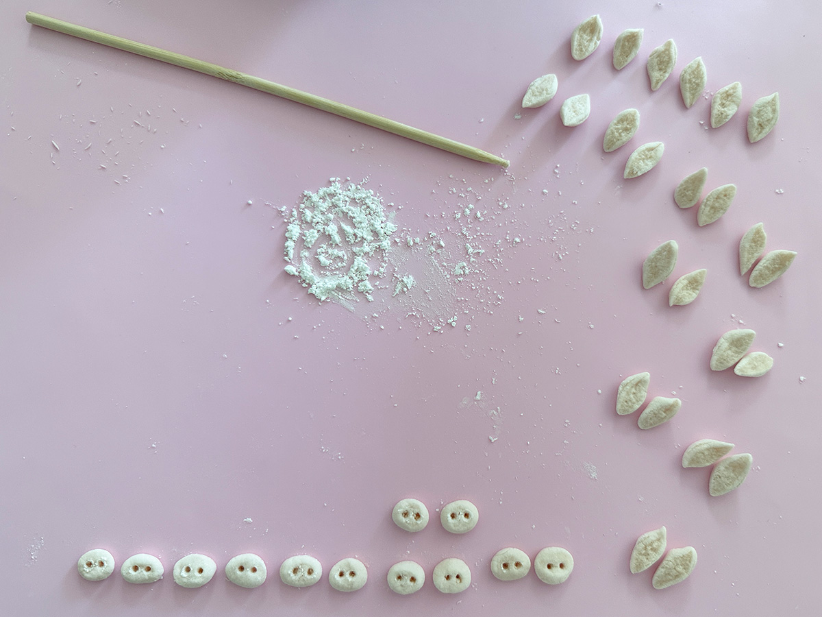 a pink silicone mat with 12 marshmallow pig snouts and 24 marshmallow pig ears on it.