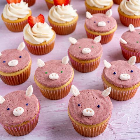 pink pig cupcakes with strawberry heart cupcakes in the background.