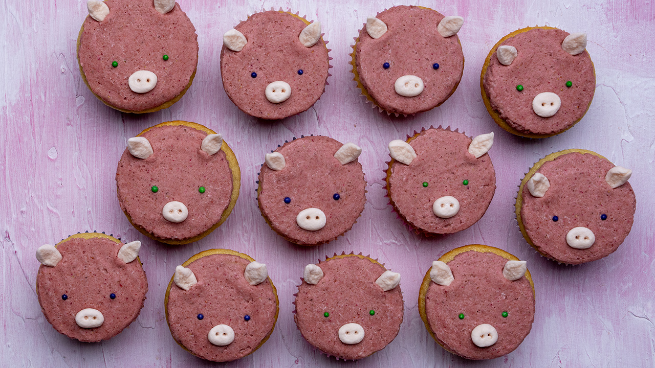 12 vegan naturally-colored pink pig cupcakes.