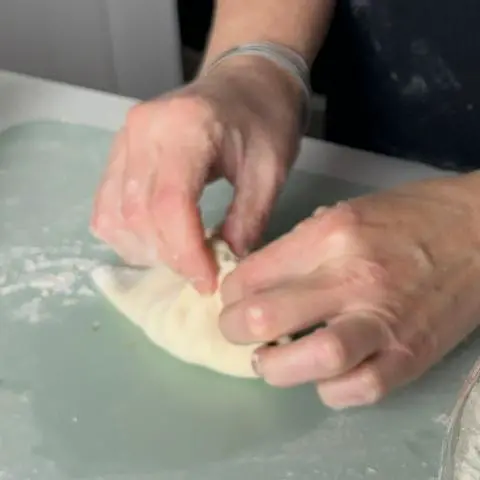 sealing the dough for the vegan pizza donuts.