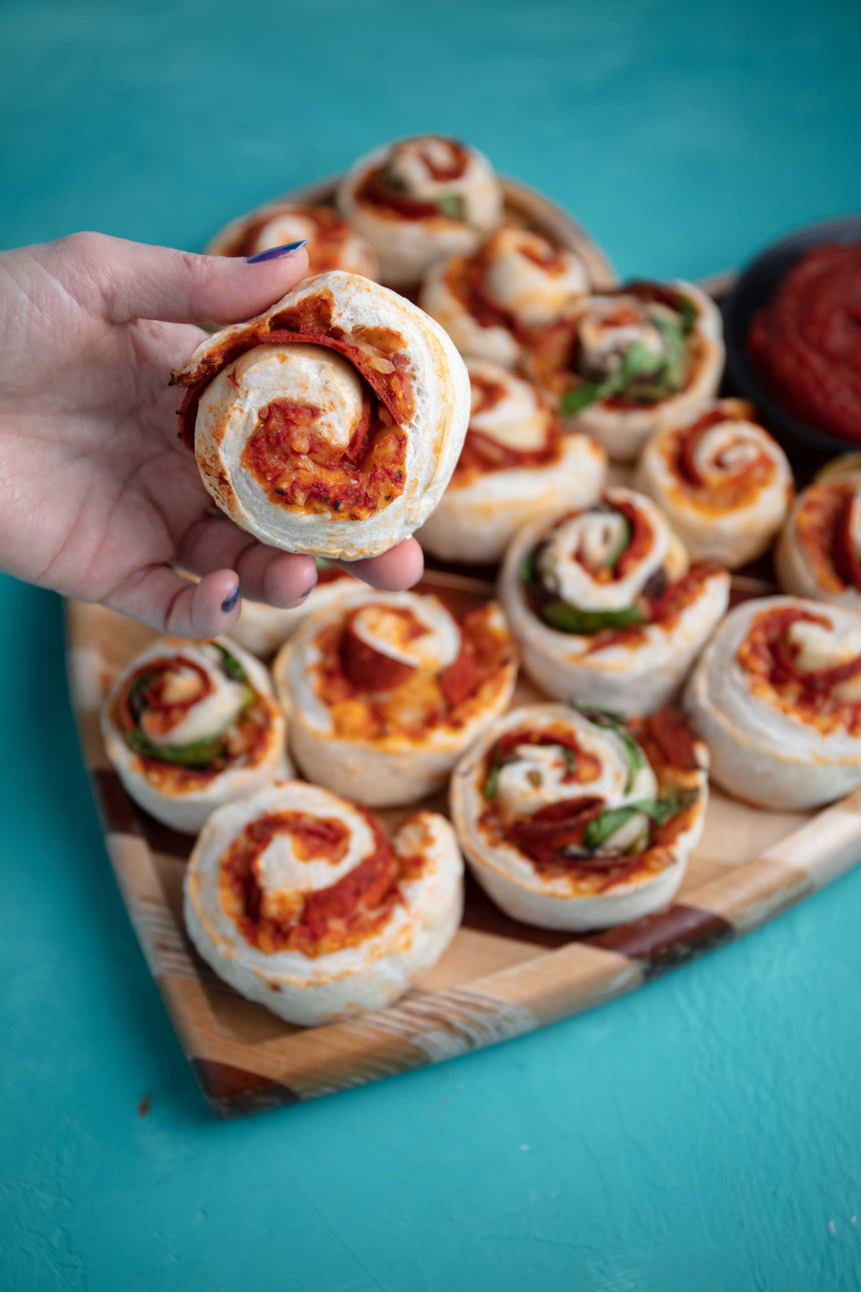 holding a vegan pizza roll closer to the camera