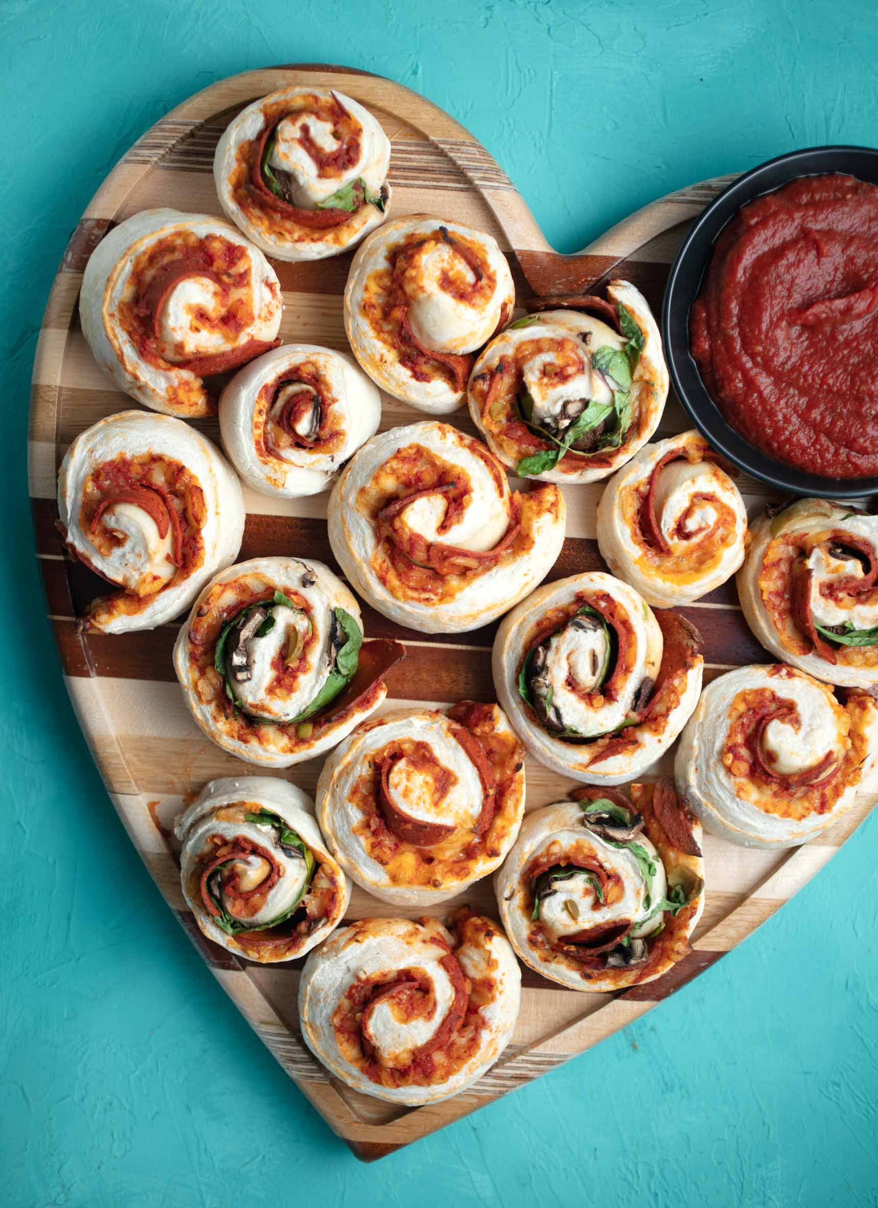 vegan homemade pizza rolls with a side of pizza sauce to dip them in