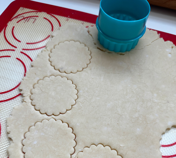 cutting out circles of vegan pie crust for the pumpkin pie cookies