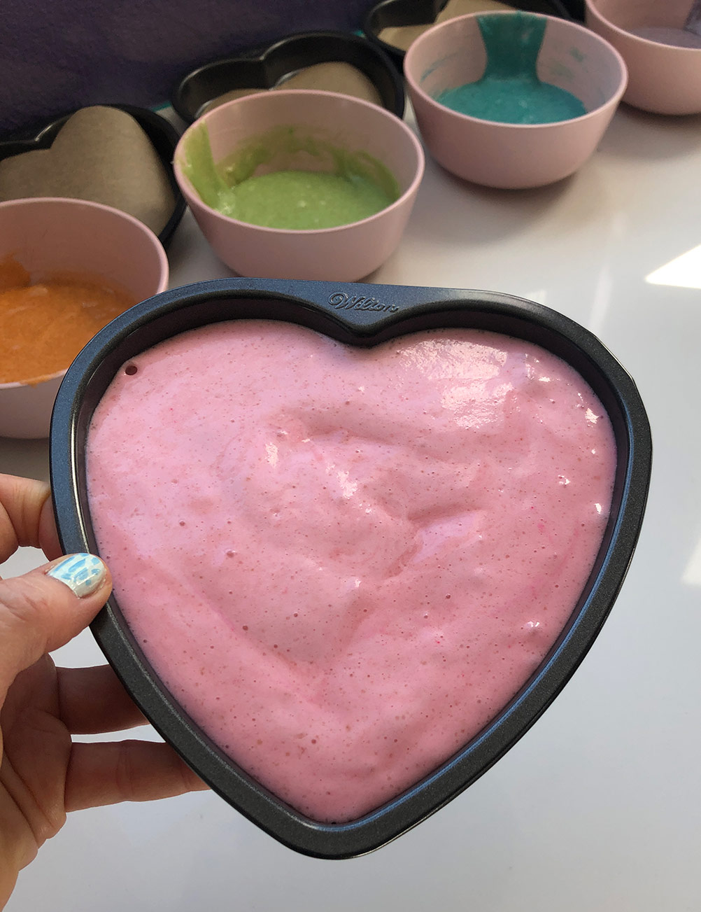 a heart shaped cake pan filled with pink vegan cake batter