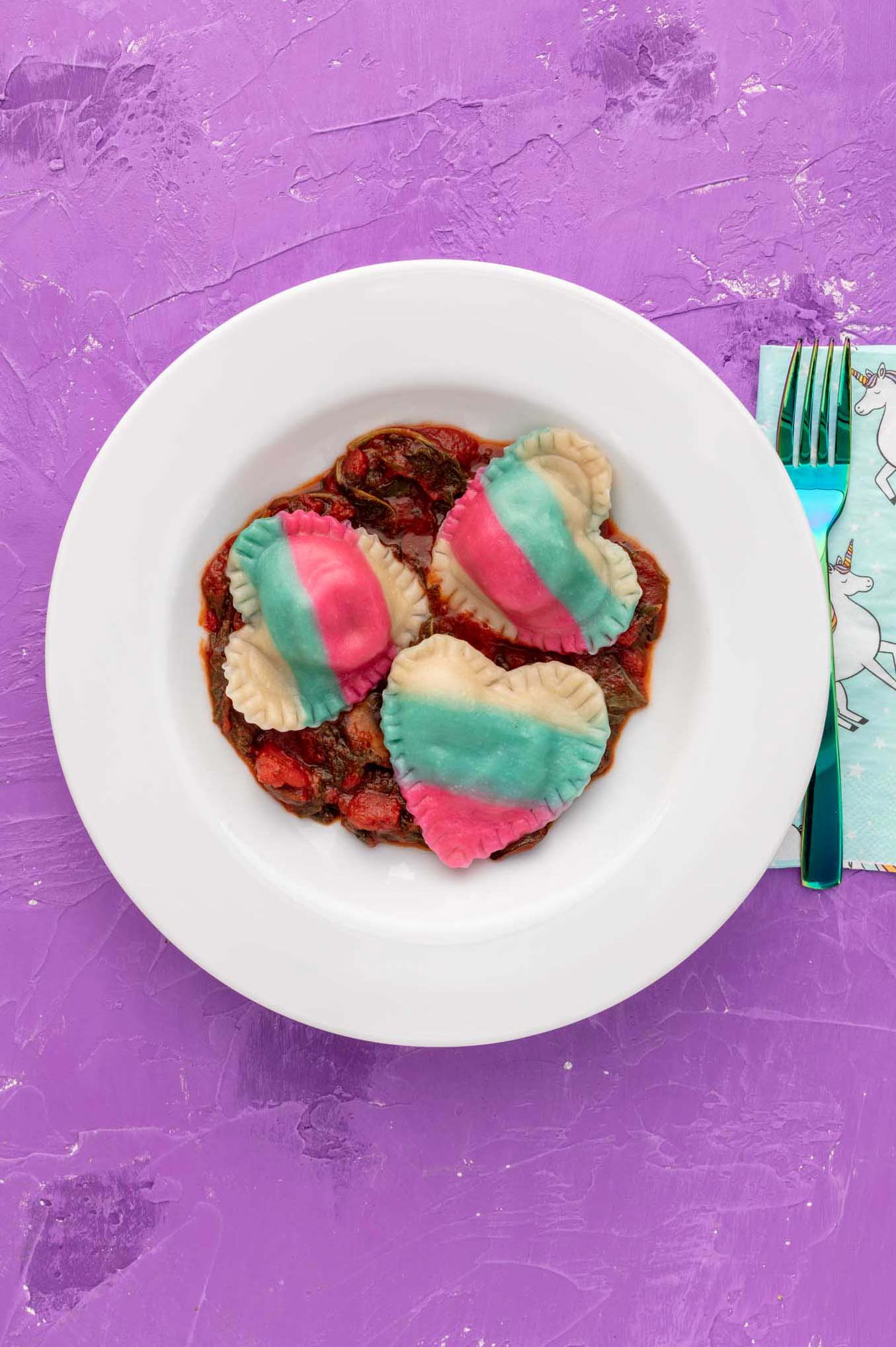 vegan heart shaped transgender flag colored ravioli on a plate with marinara