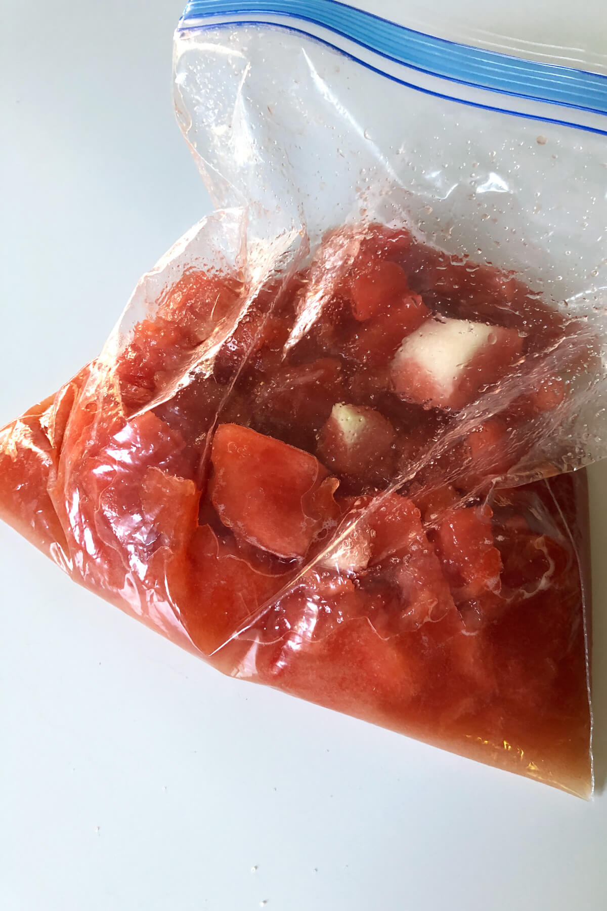 a ziplock freezer bag with watermelon, vegan sugar, and watermelon juice