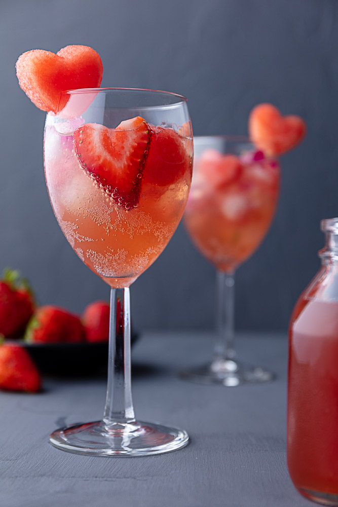 hello kitty wine glasses filled with watermelon sangria and garnished with heart shaped fruit