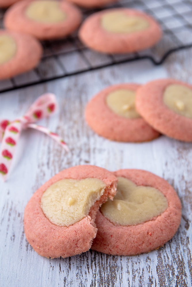 vegan strawberry cheesecake cookies with a bite missing from one