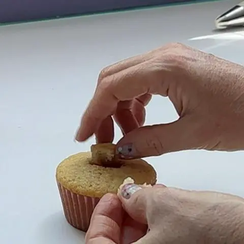 placing the piece of cupcake you removed back into the hole.