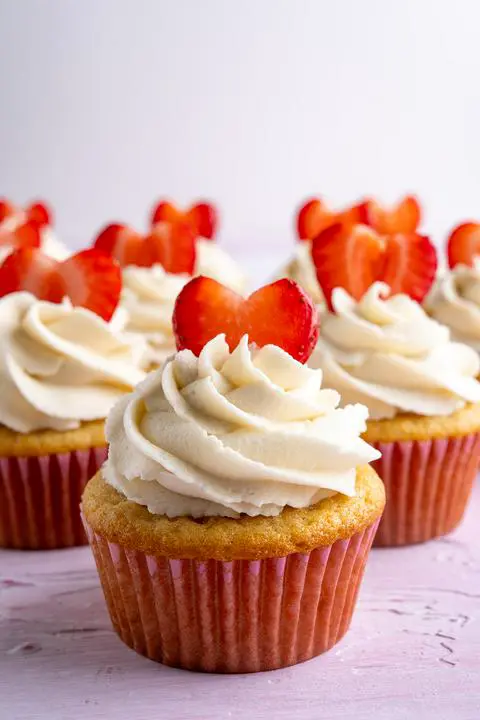 all the decorated cupcakes with just one main one in focus and the rest out of focus.