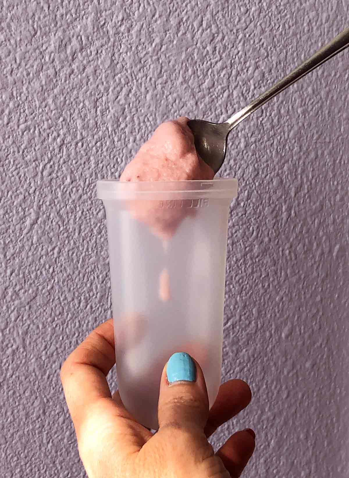 filling popsicle molds with vegan strawberry ice cream