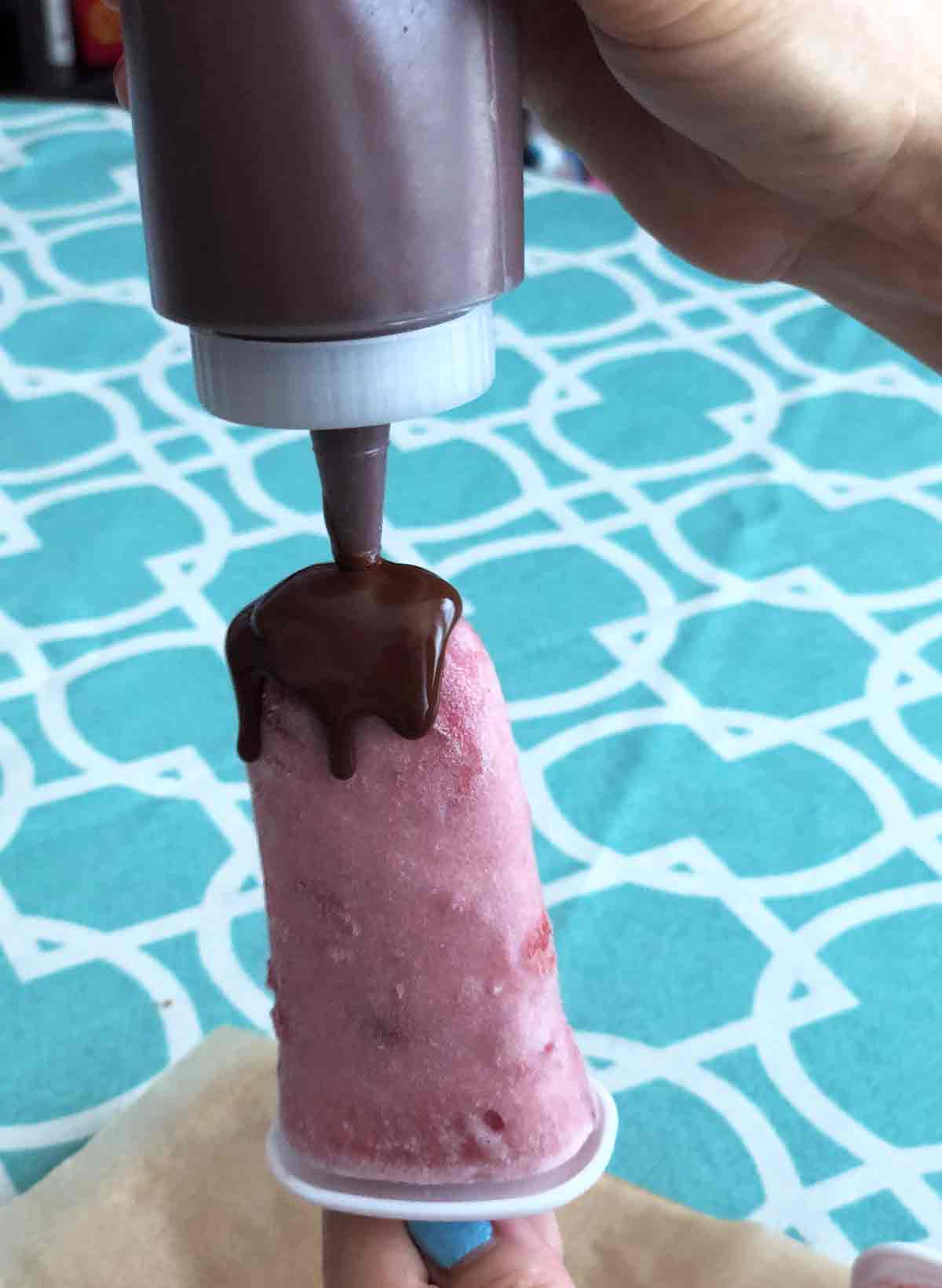 adding penguin coat to some of the vegan strawberry ice cream popsicles