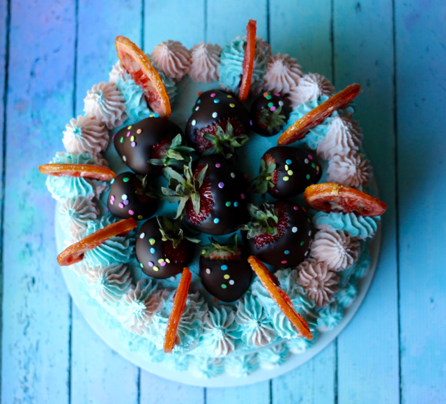 top view of a cake with chocolate covered strawberries on top