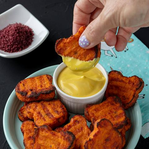 dipping a bear shaped sweet potato tot in dip