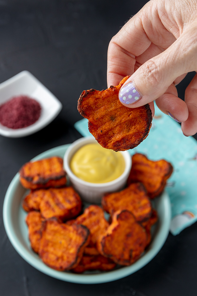 holding a vegan sweet potato tater tots that is shaped like a bear