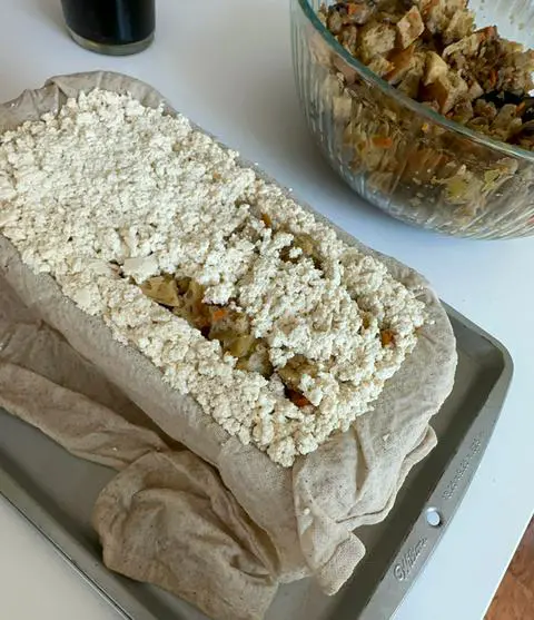 adding more tofu to the top of the stuffing to enclose it