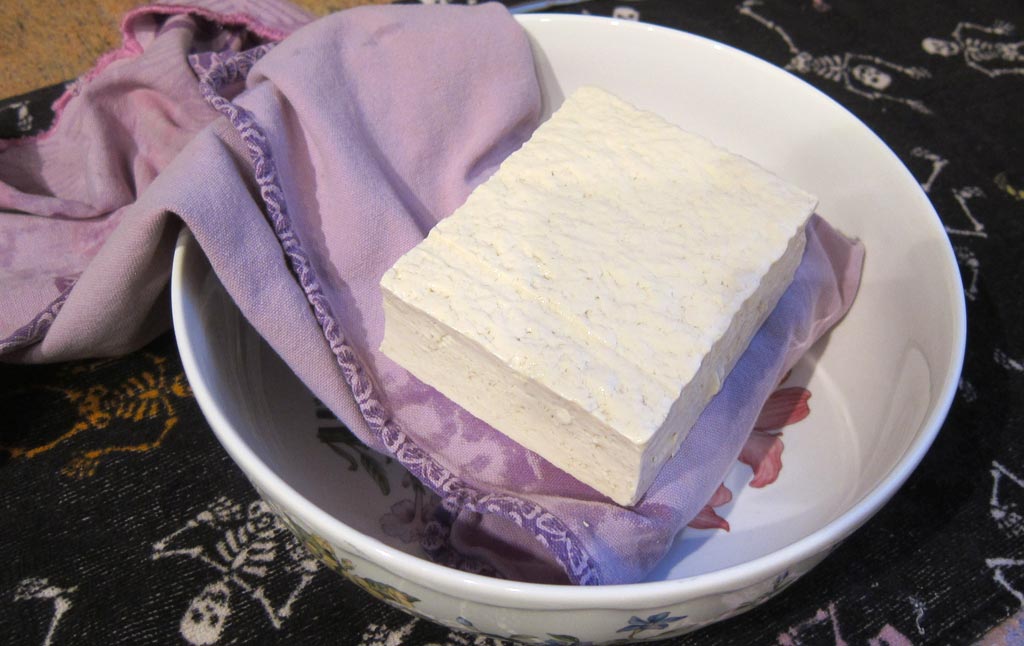 a block of tofu wrapped in a tea towel