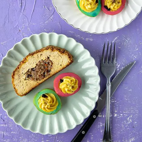 Vegan Thanksgiving plate with tofu turkey filled with heart-shaped stuffing and colored deviled eggs