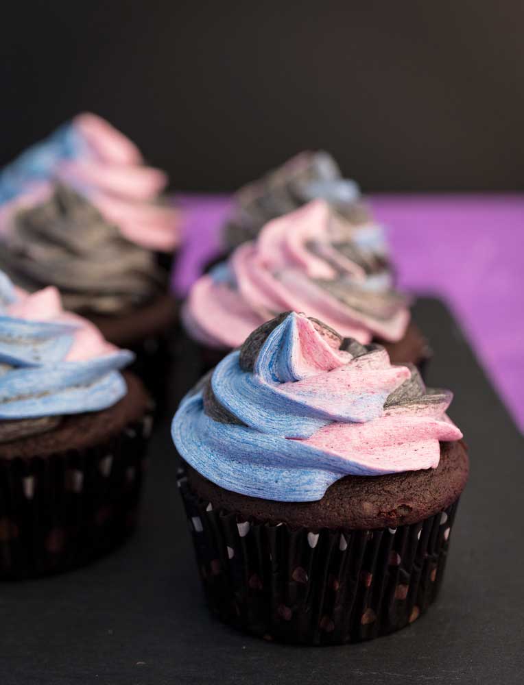 chocolate cupcakes with multi-colored frosting swirled on top