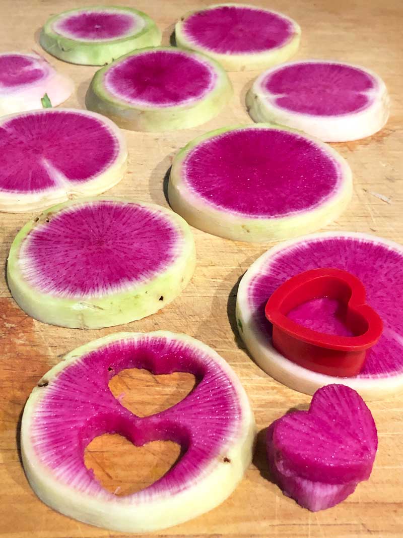Cutting out heart shaped watermelon radishes